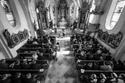 Innenaufnahme der Kirche mit den Gästen und dem Brautpaar