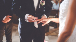 Bräutigam steckt den Ring an den Finger der Braut